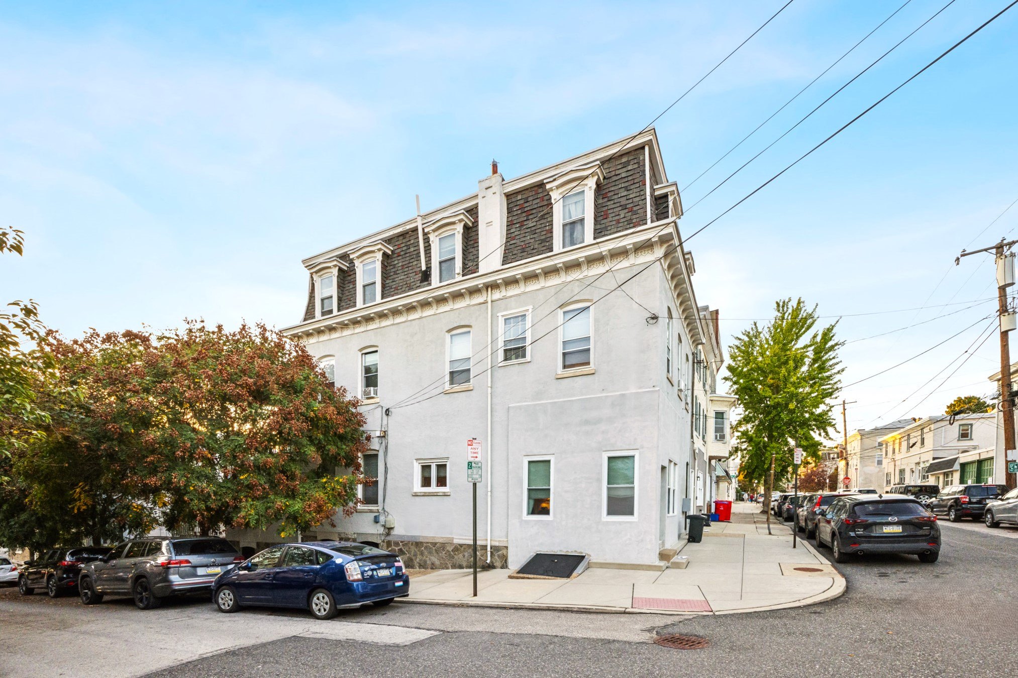 a white building with cars parked in front of it on a city street